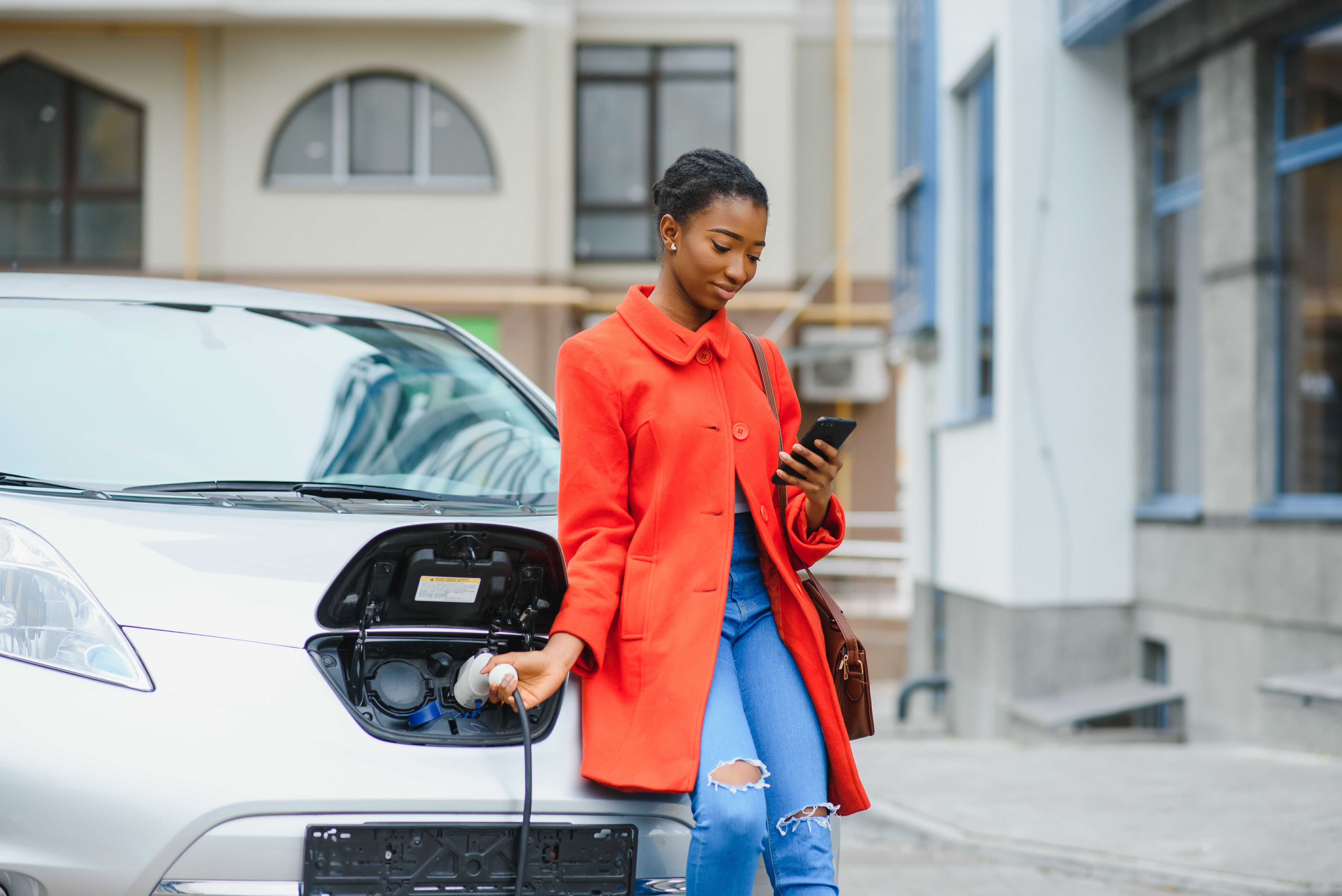 Young woman charging her EV