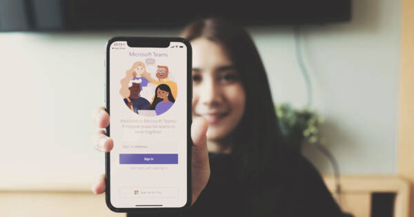 Woman showing Microsoft Teams software on smartphone